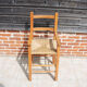 Old wooden high chair for children with straw.