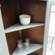 Vintage English corner display cabinet enhanced in grey-green with a wooden top.