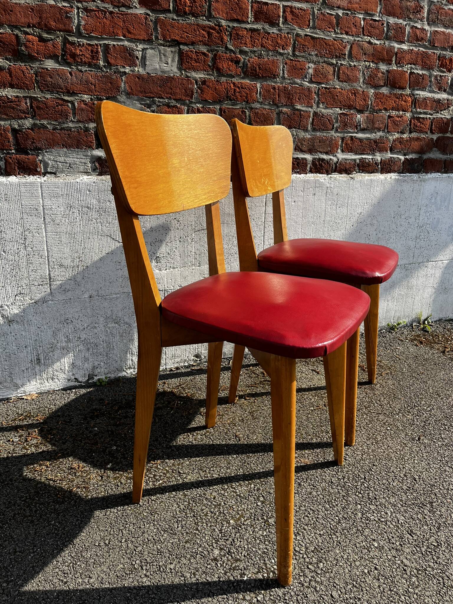 Set of 4 vintage bistro chairs in wood and red faux leather, with splayed legs.