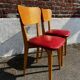 Set of 4 vintage bistro chairs in wood and red faux leather, with splayed legs.