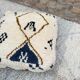 Berber floor pouf: Handwoven Moroccan wool cushion.