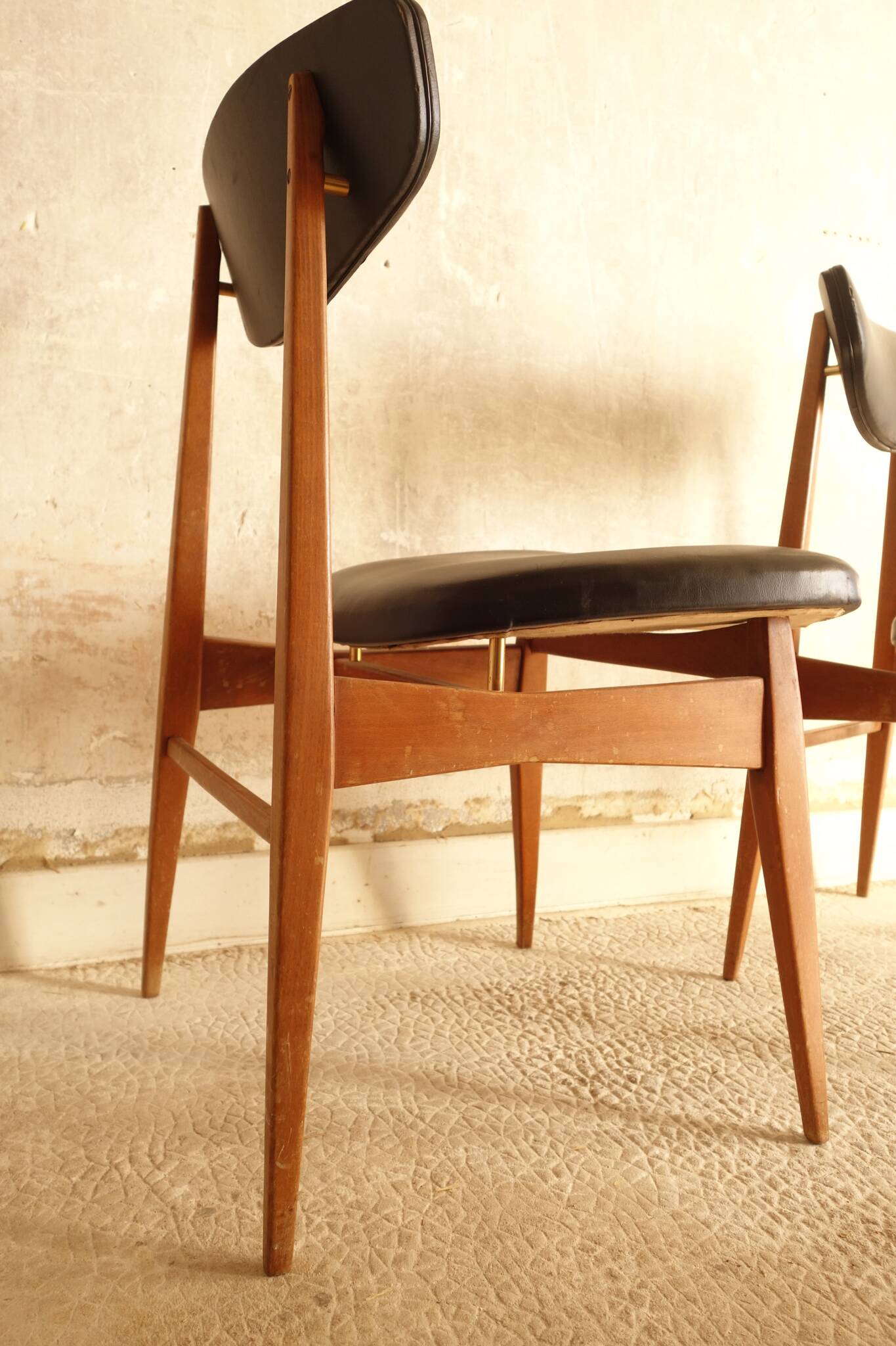 Pair of modernist Scandinavian chairs in teak and black faux leather.