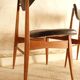 Pair of modernist Scandinavian chairs in teak and black faux leather.
