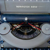 portable Remington typewriter with its suitcase and original cover