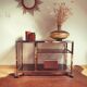 Service table with vintage brass wheels / smoked glass