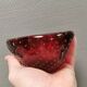 Small glass bowl in beautiful emerald red color with inlaid bubbles.