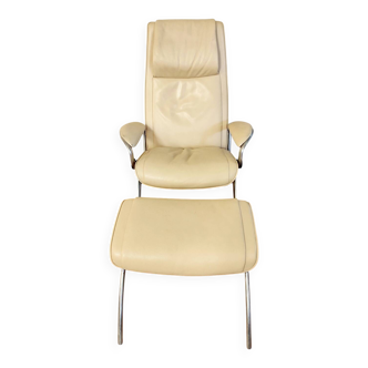 Fauteuil en cuir beige et repose-pieds