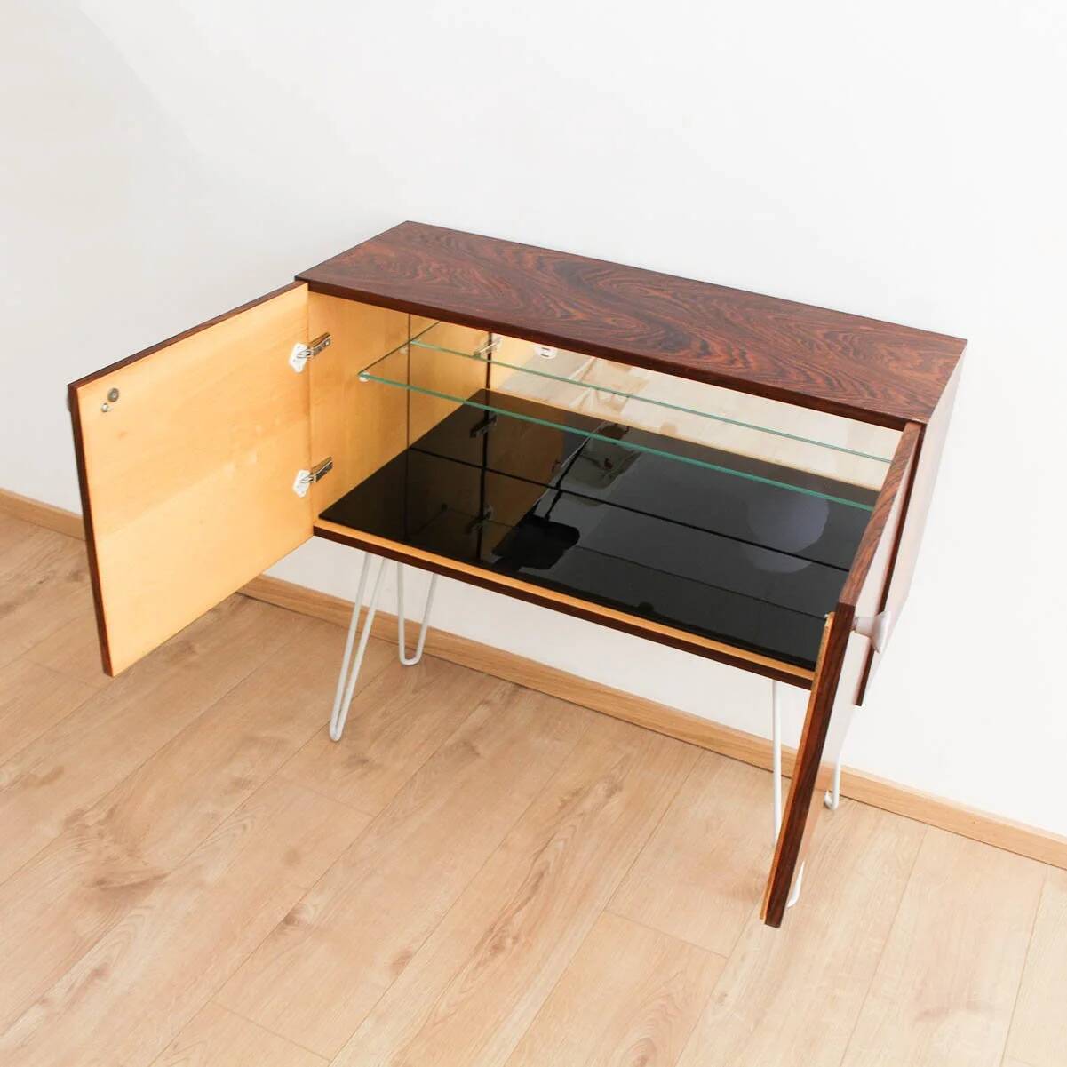 Buffet en palissandre avec des pieds en métal gris clair en forme de épingle.