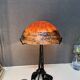 Contemporary mushroom lamp, wrought iron base and shaded orange glass shell