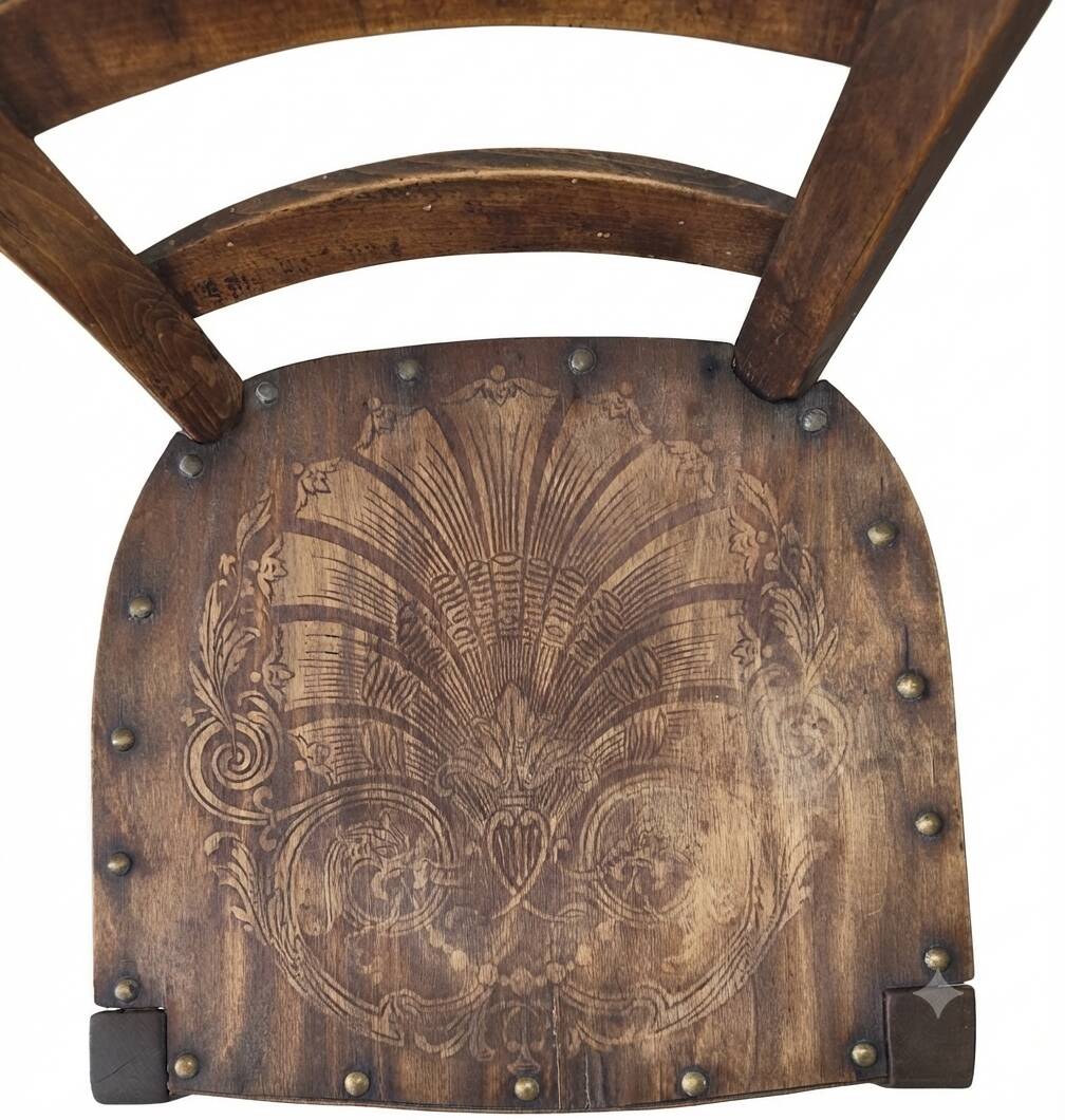 Antique wooden chair with a pyrographed shell motif seat.