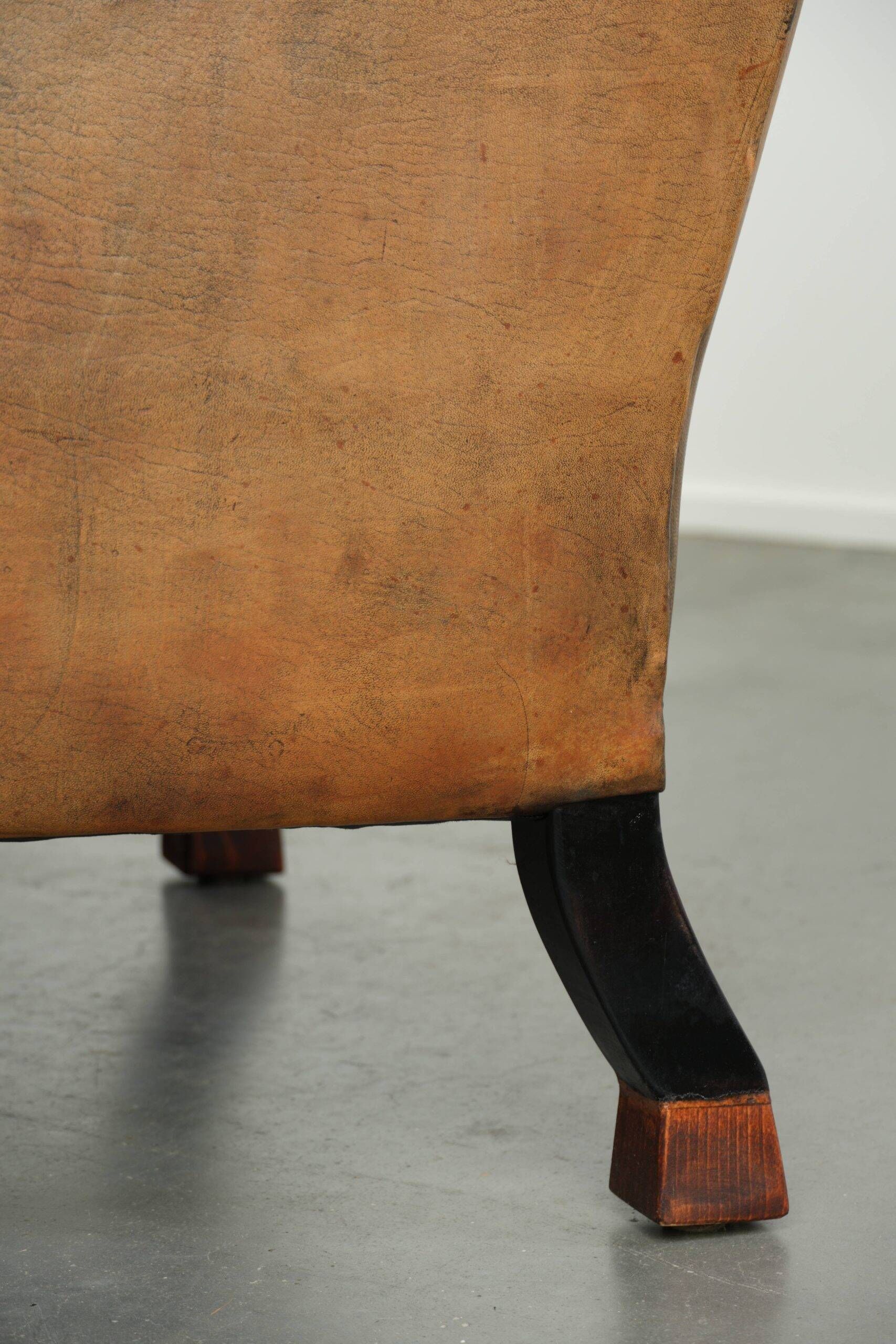 Sheepskin wingback armchair with patina finished with decorative nails