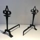 Important pair of wrought iron andirons with torch in heraldic fleur-de-lis design.
