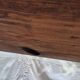 Brutalist wooden bench made of solid oak beam.