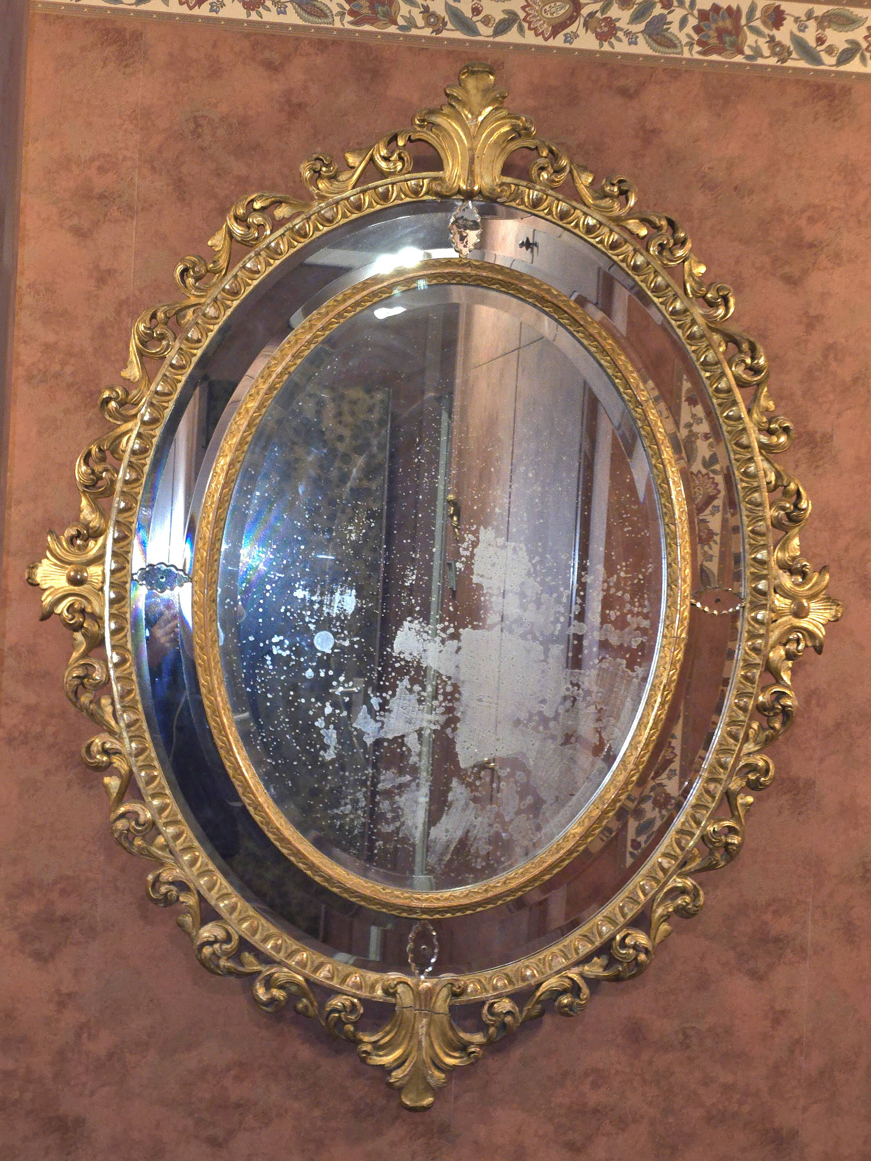 Oval mirror in gilded wood