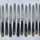 Set of 12 dessert knives with two-tone horn-effect resin handles.