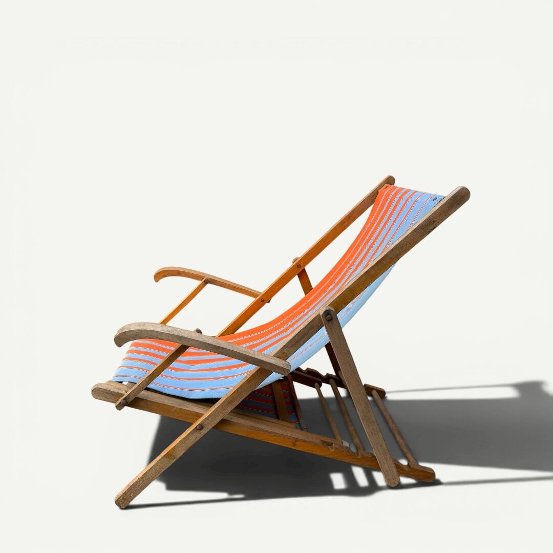 Vintage deck chair with orange and blue striped fabric, original patina.