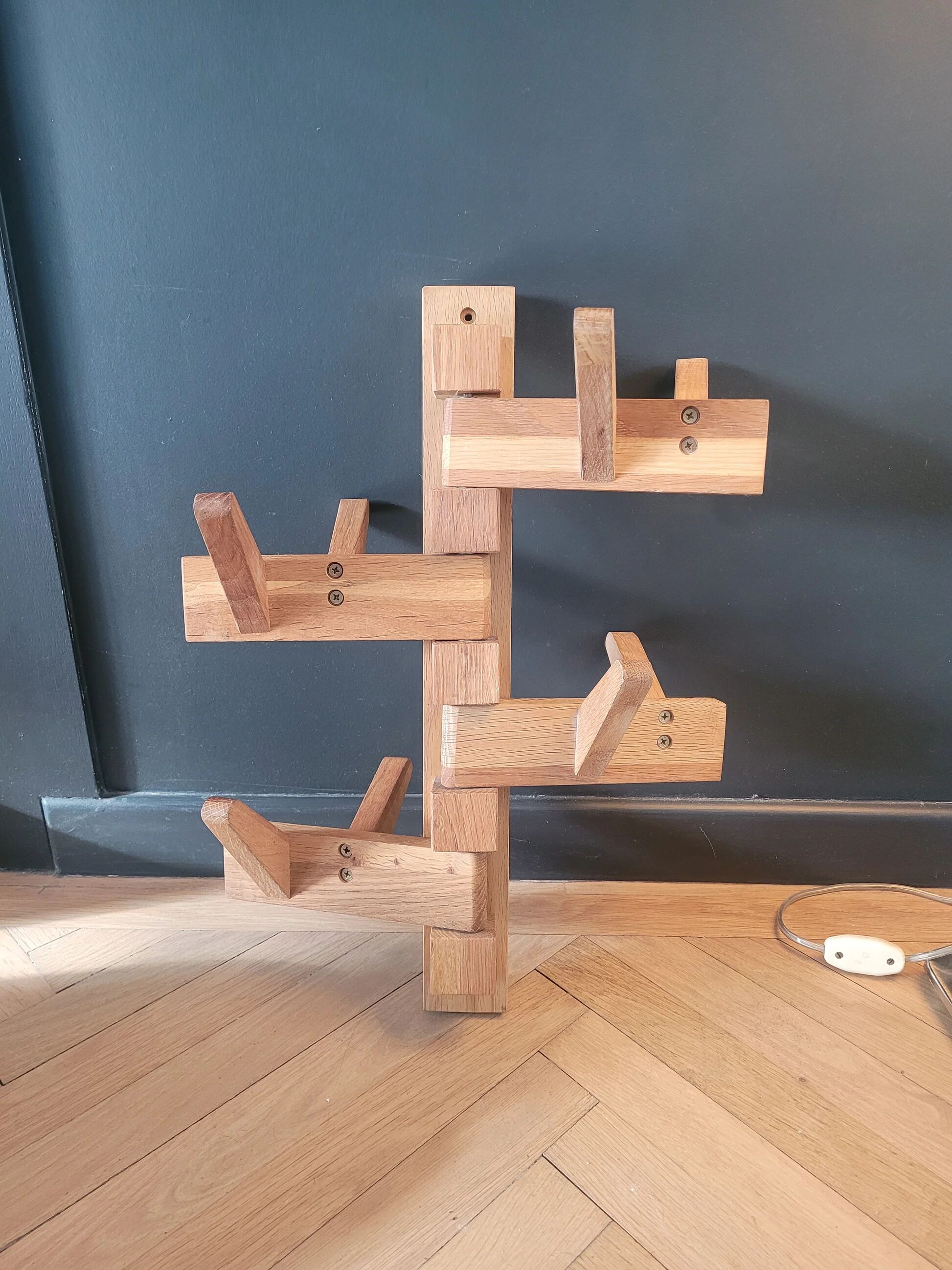 Articulated vertical wall coat rack