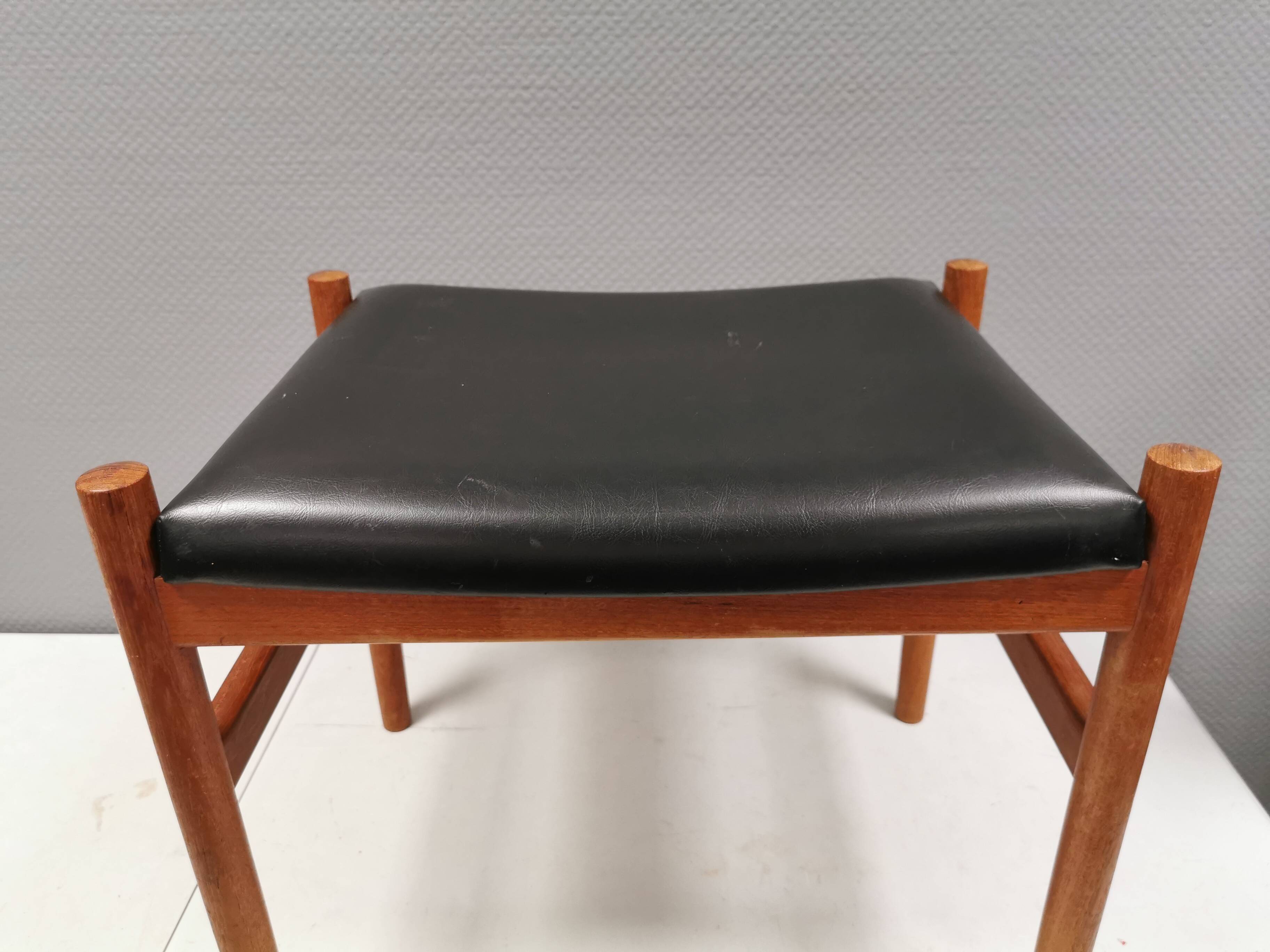 Danish designed footstool in teak wood and black skai “imitation leather”