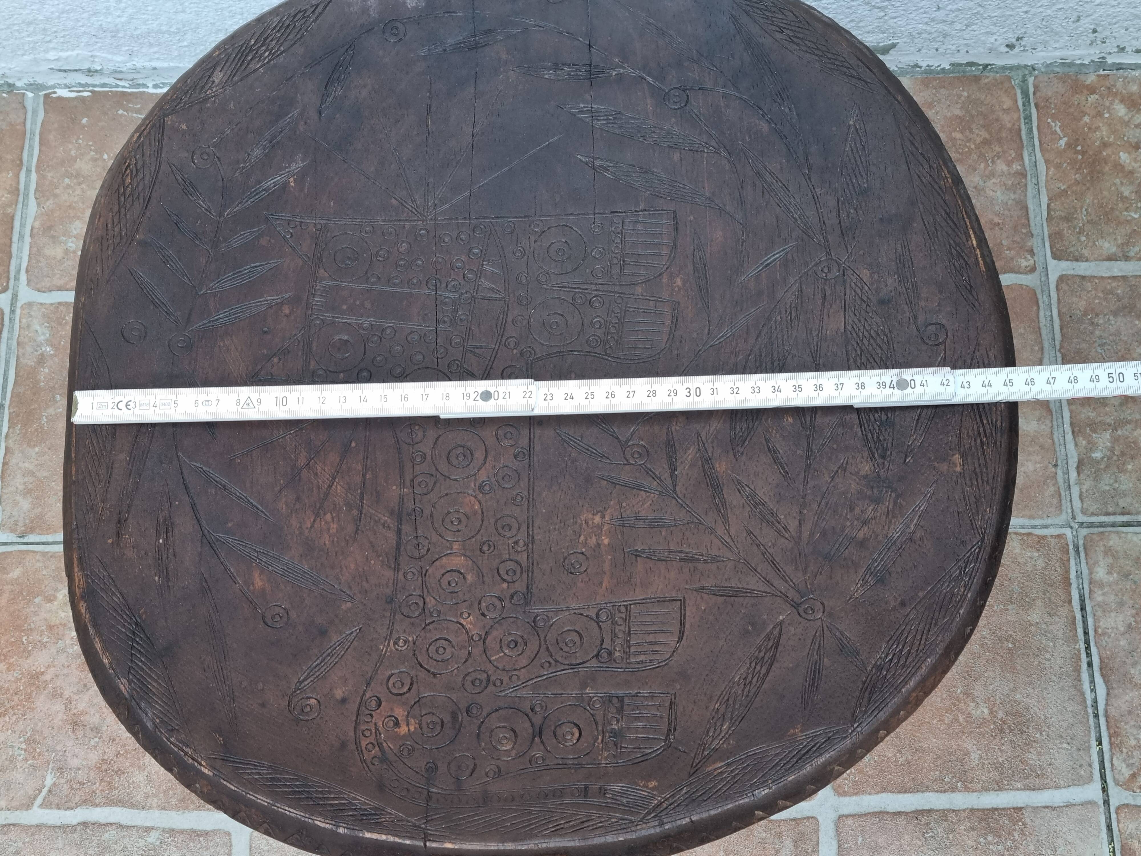 African monoxyle side table in carved wood with a curved top, 48x36 cm.