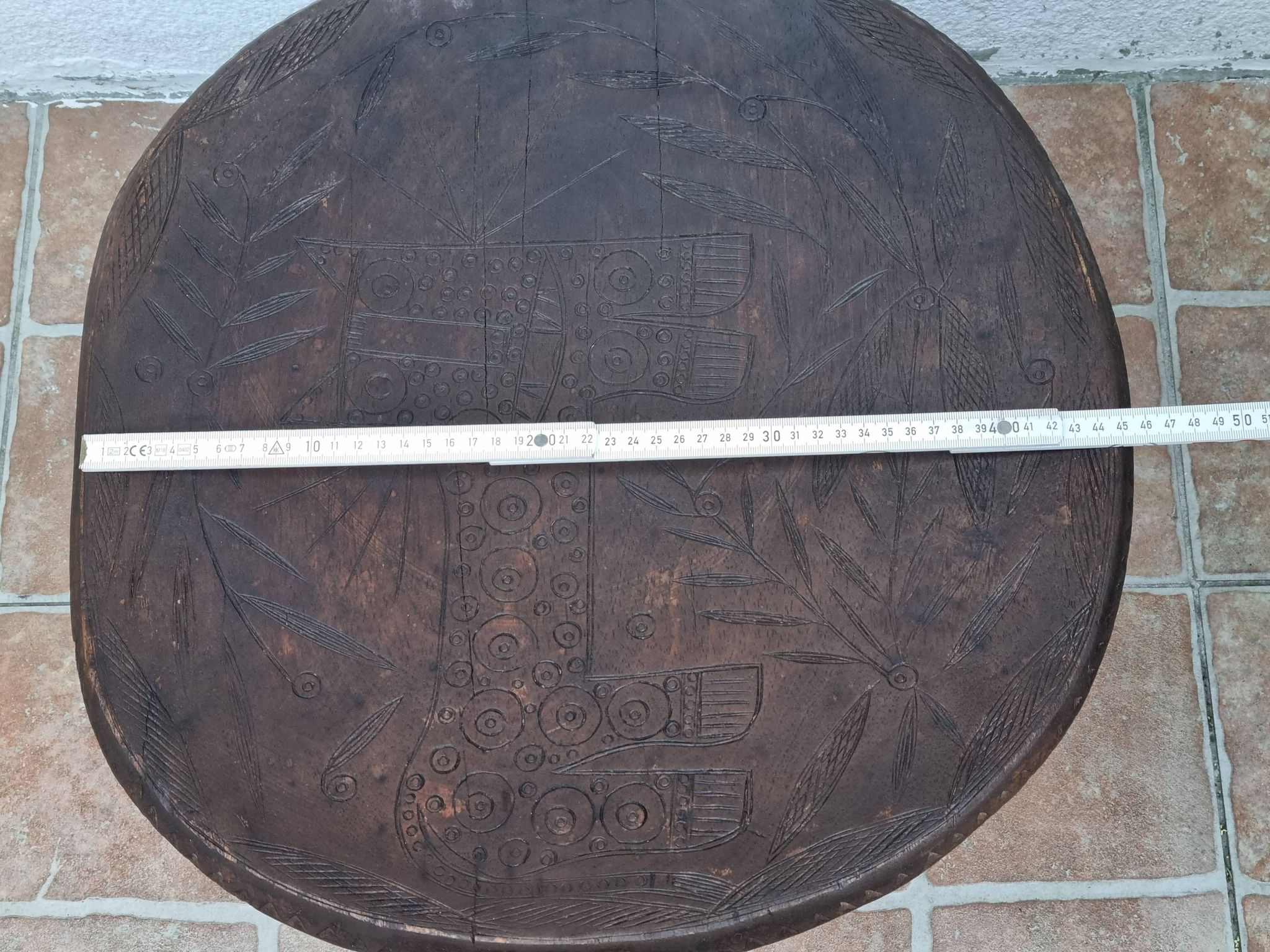 African monoxyle side table in carved wood with a curved top, 48x36 cm.