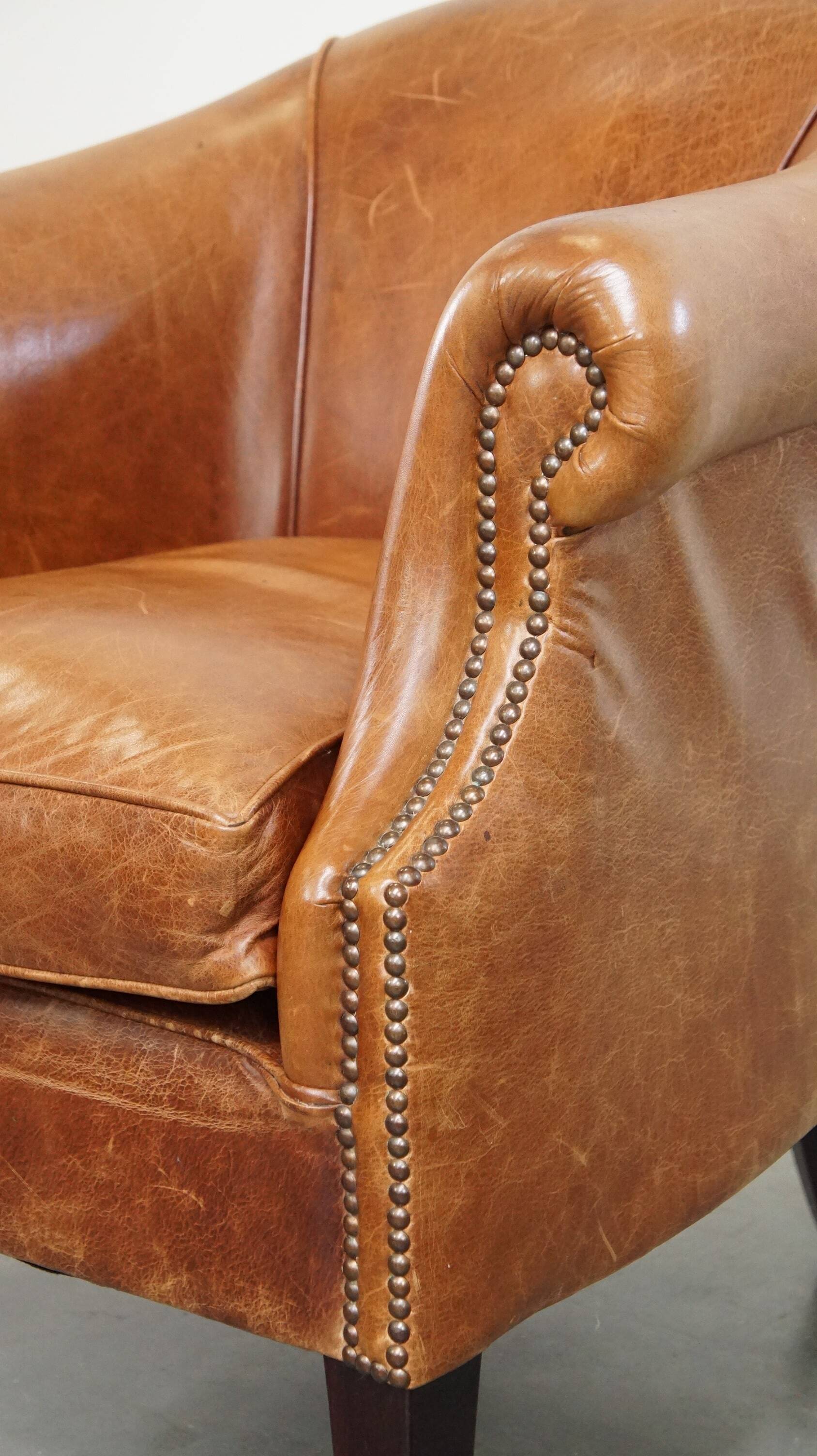 Very comfortable, elegant leather club armchair with a removable seat cushion and timeless design