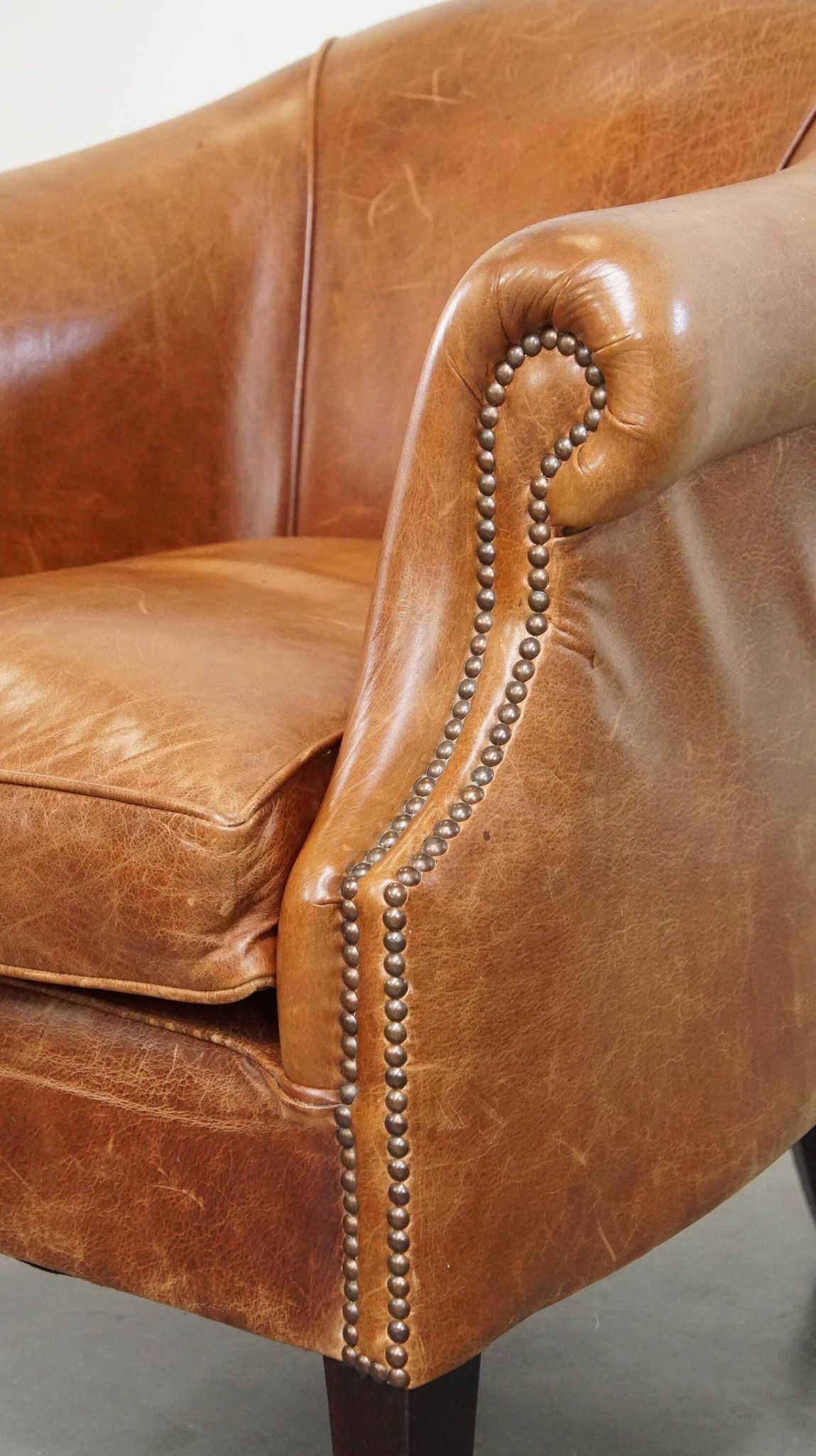 Very comfortable, elegant leather club armchair with a removable seat cushion and timeless design