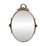 Beveled oval mirror in gilded bronze