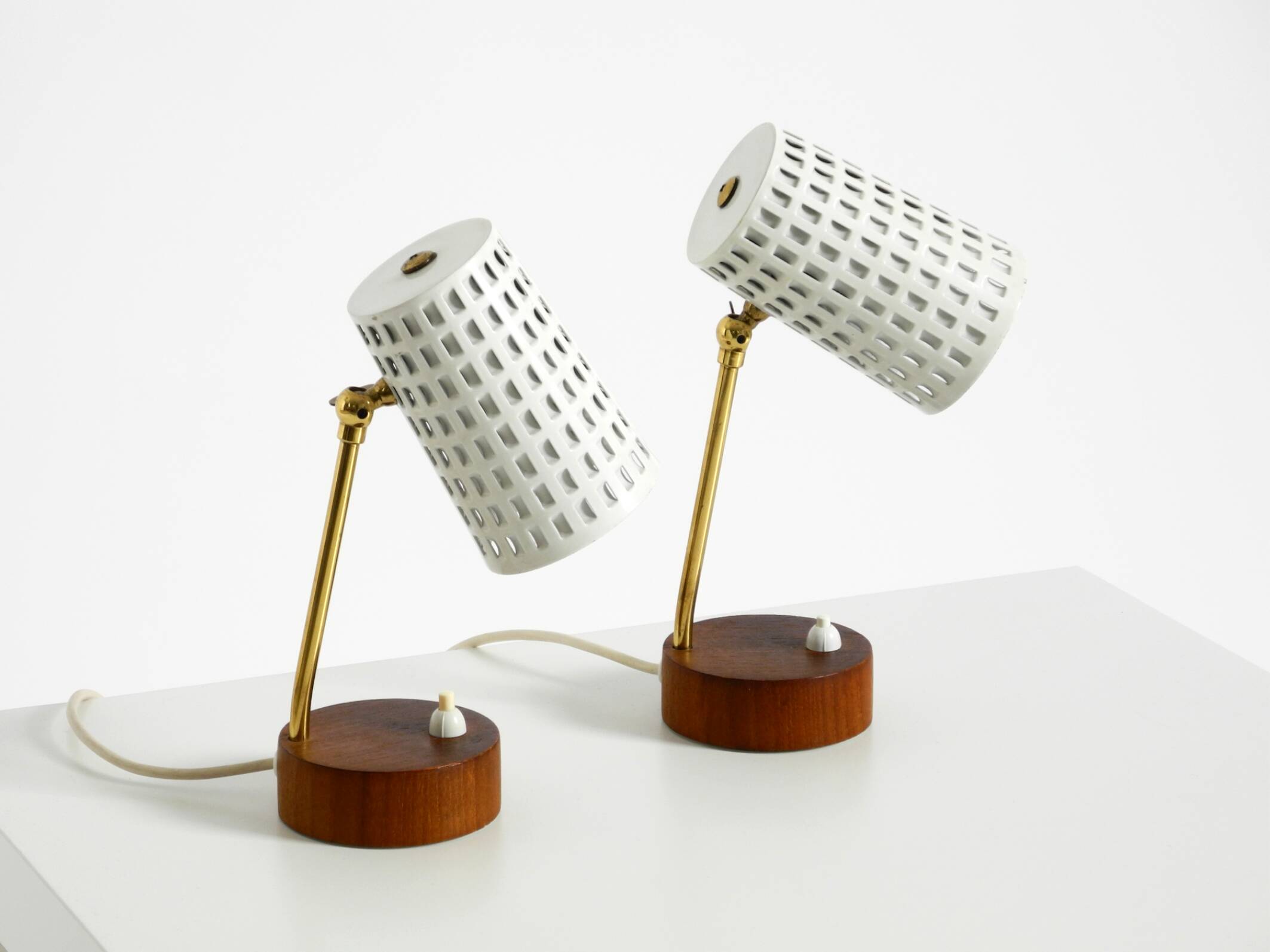 A pair of mid-century modern bedside lamps with perforated metal shades
