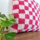 Berber cushion with a pink checkerboard pattern.