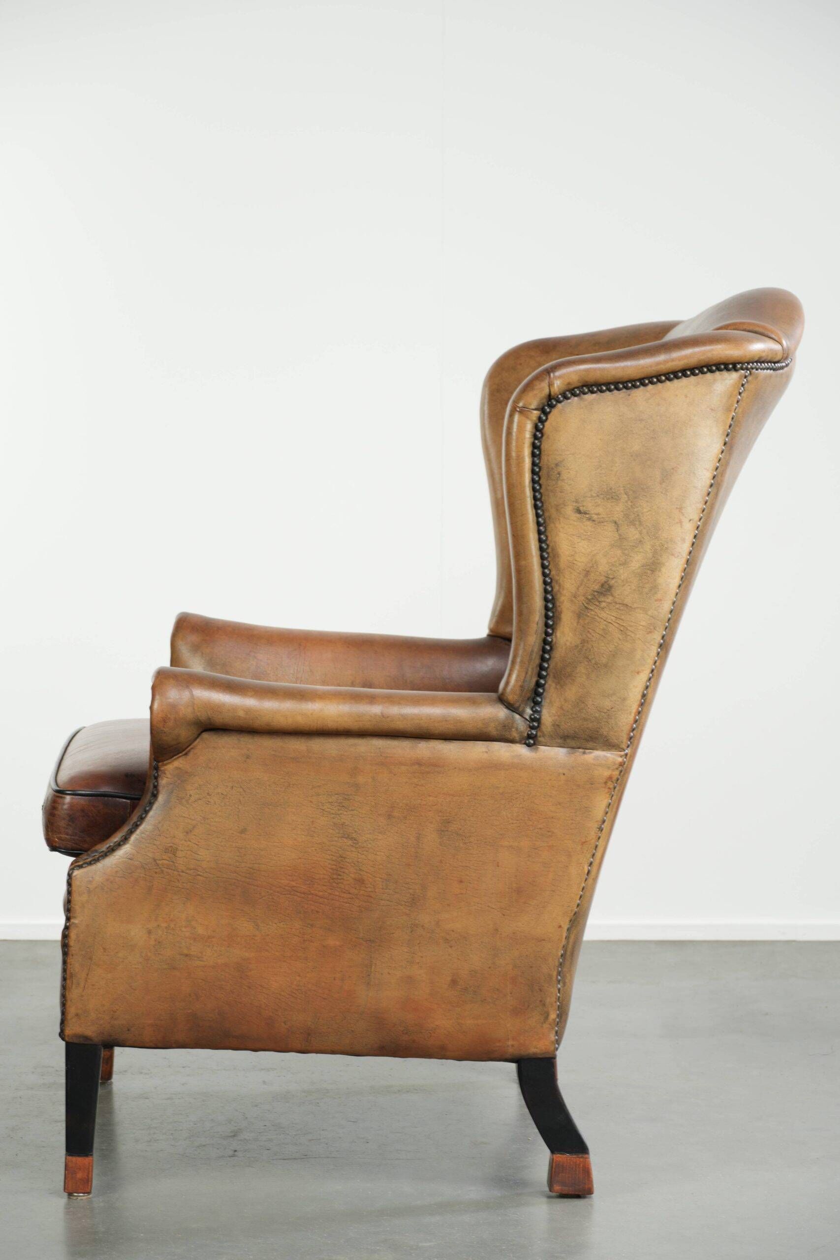 Sheepskin wingback armchair with patina finished with decorative nails