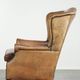Sheepskin wingback armchair with patina finished with decorative nails