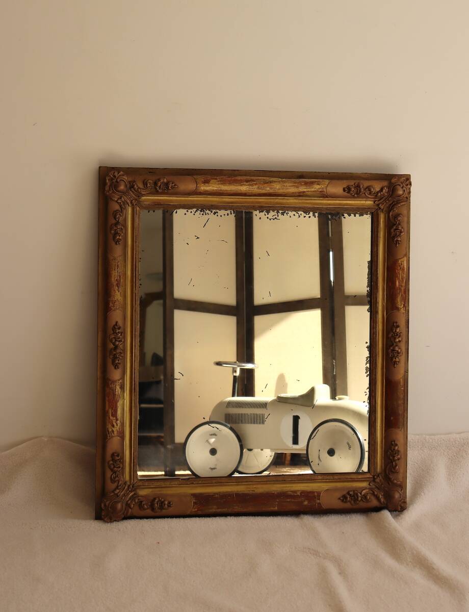 Rectangular mirror in gilded wood with relief decoration of flowers.