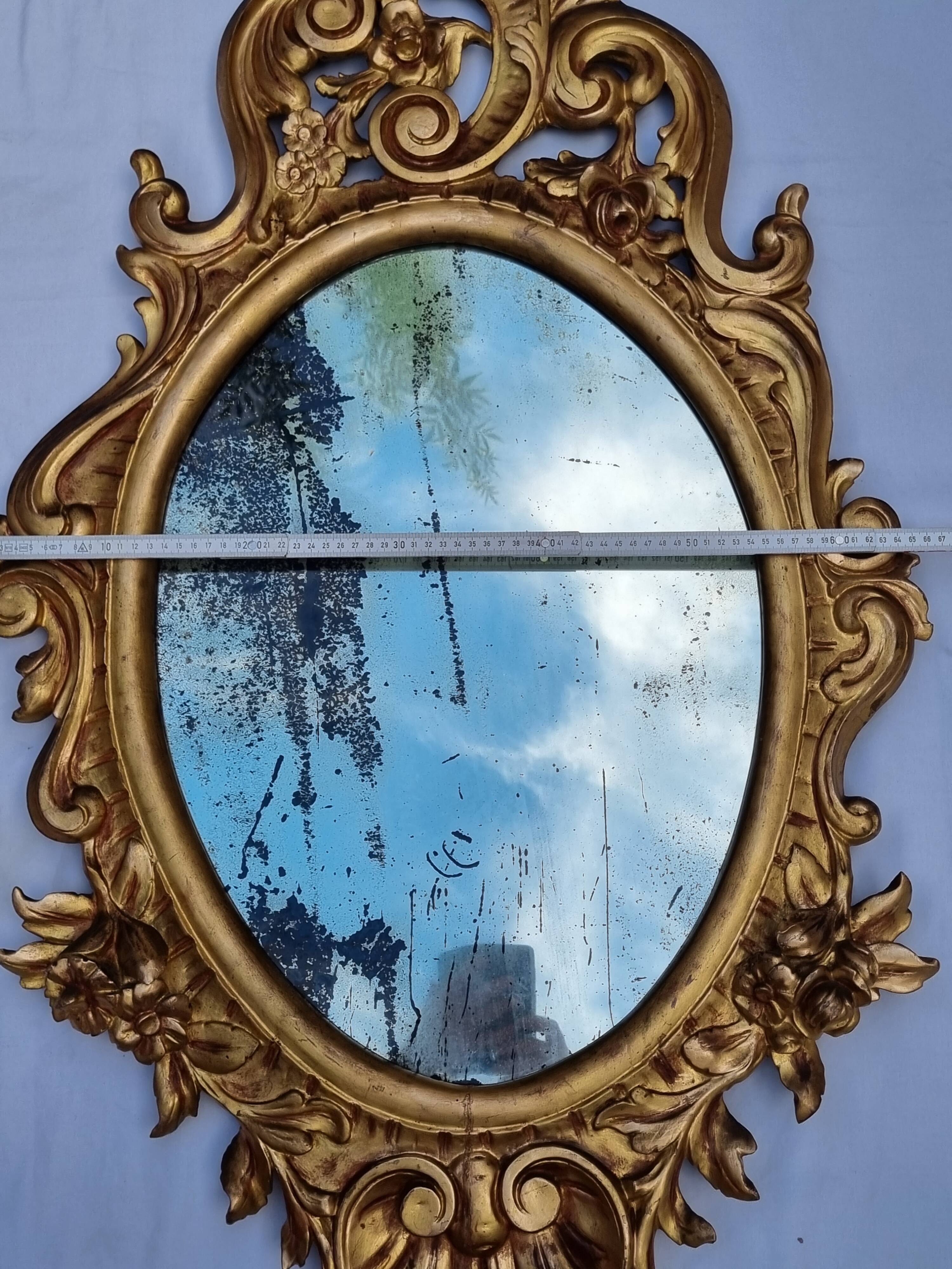 Large oval gold mirror, Louis XV rococo style, late 19th century, 114 x 66 cm.