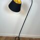 Design floor lamp in black lacquered metal and brass.