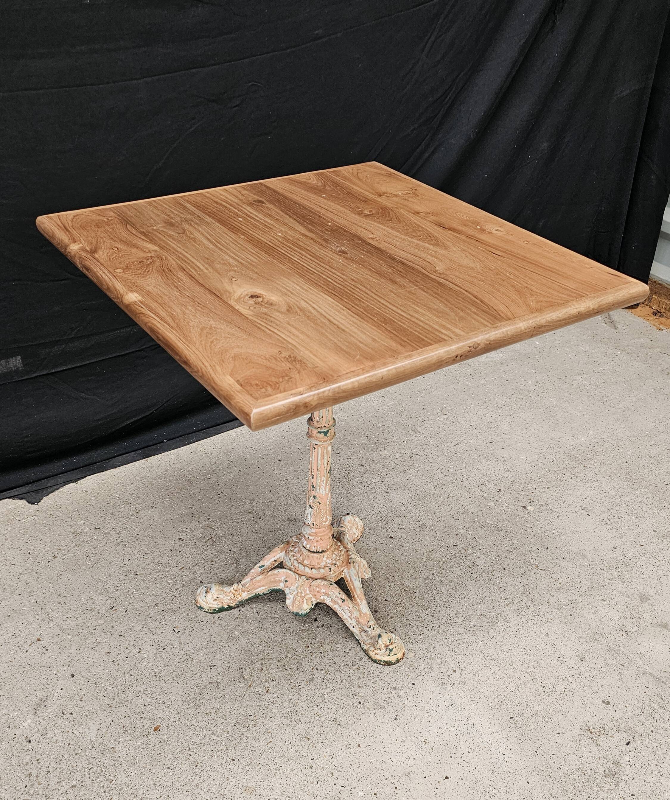 Bistro table with cast iron base and solid teak top