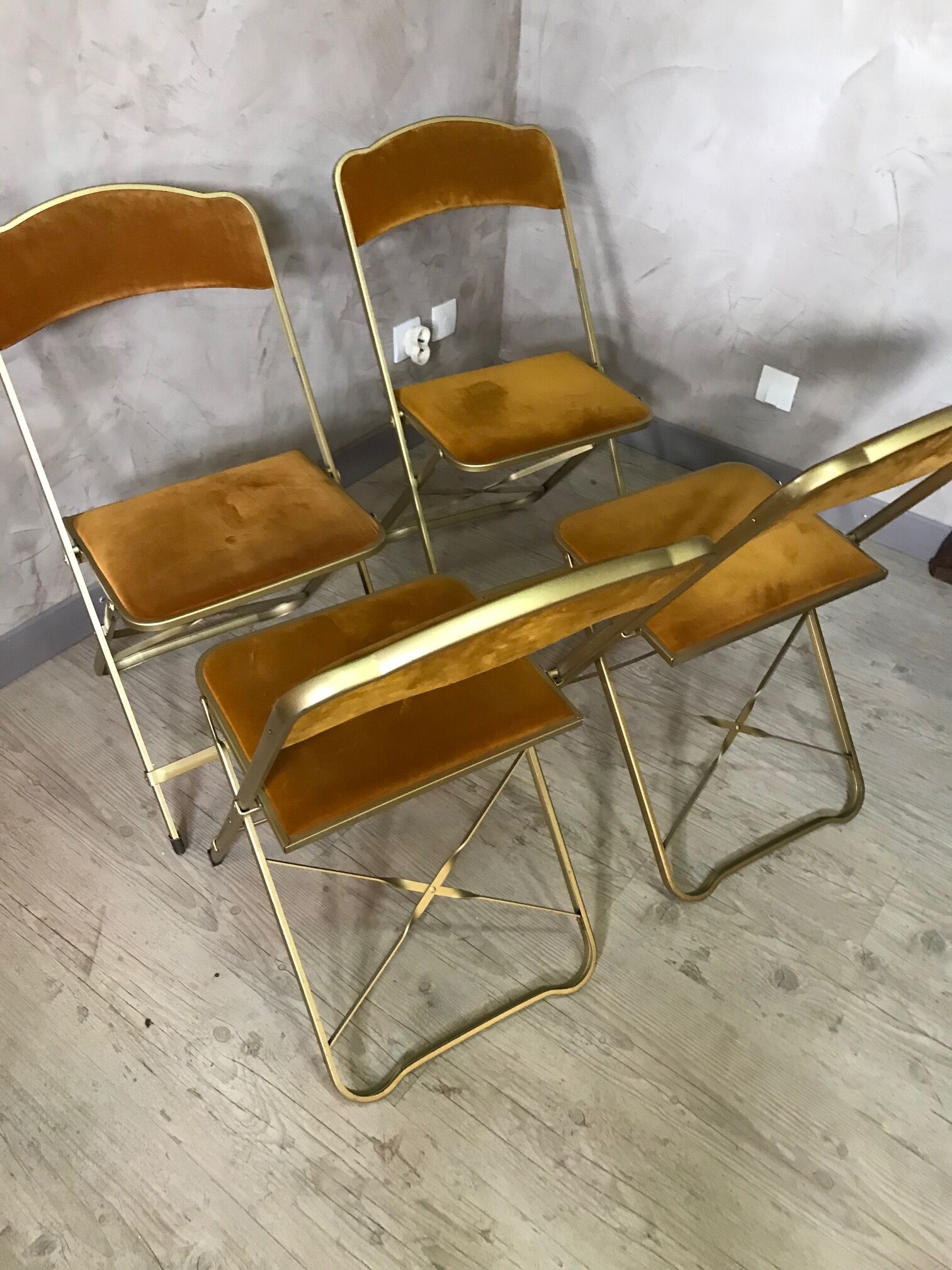 Four folding velvet and brass chairs