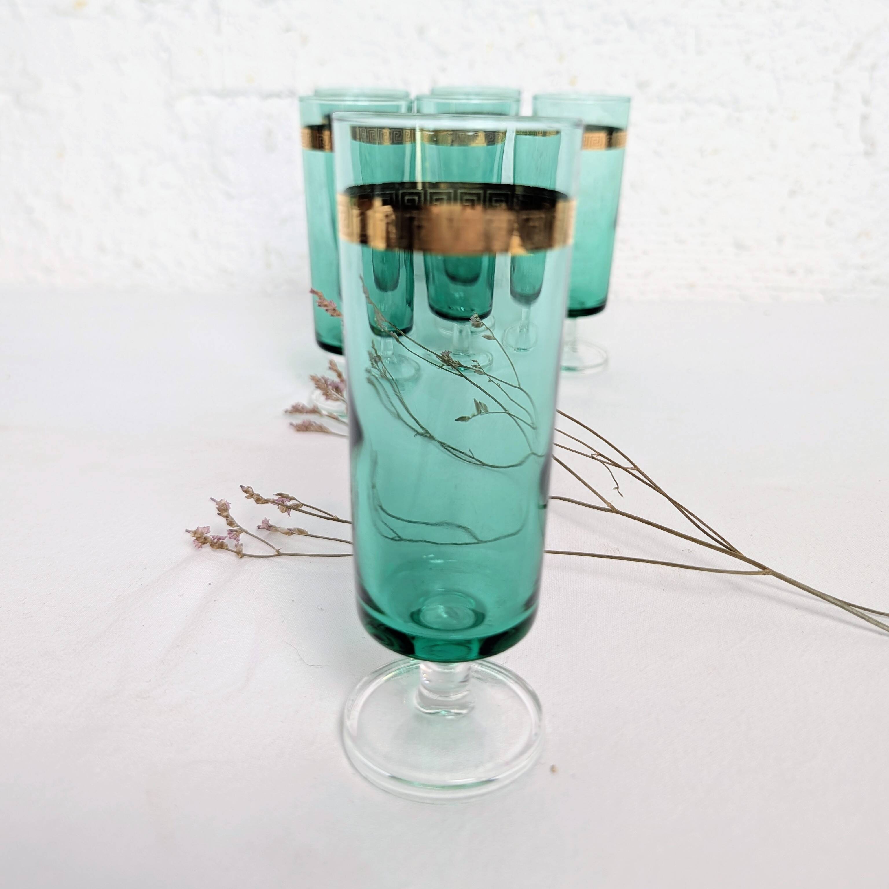 Set of 6 green champagne flutes with a golden rim.