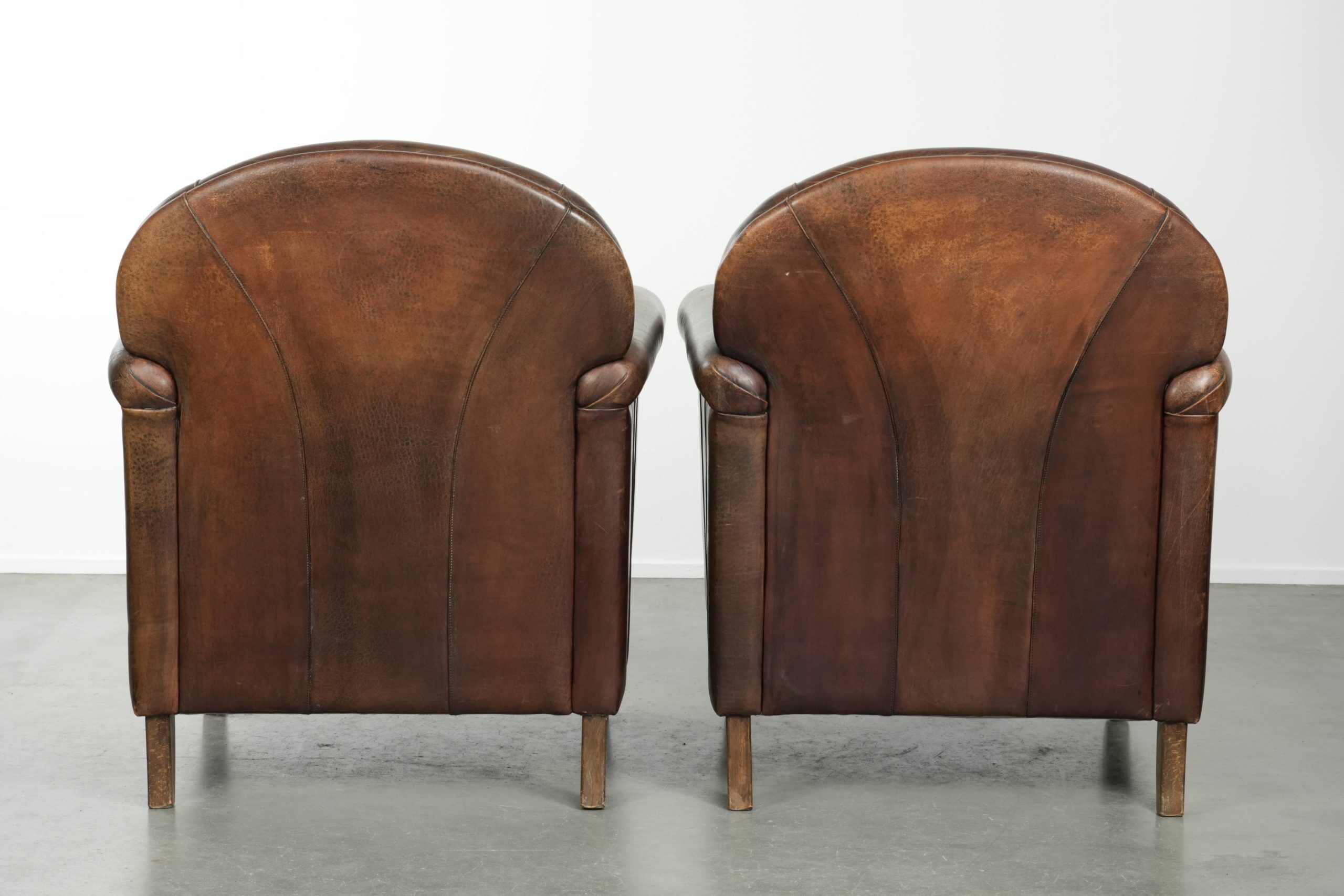 Characterful set of two sheepskin design armchairs with beautiful patina