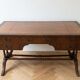 Antique wooden desk with a faux leather top and extensions.