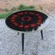 Vintage coffee table with glass top and tripod legs in blackened wood from the 1960s.