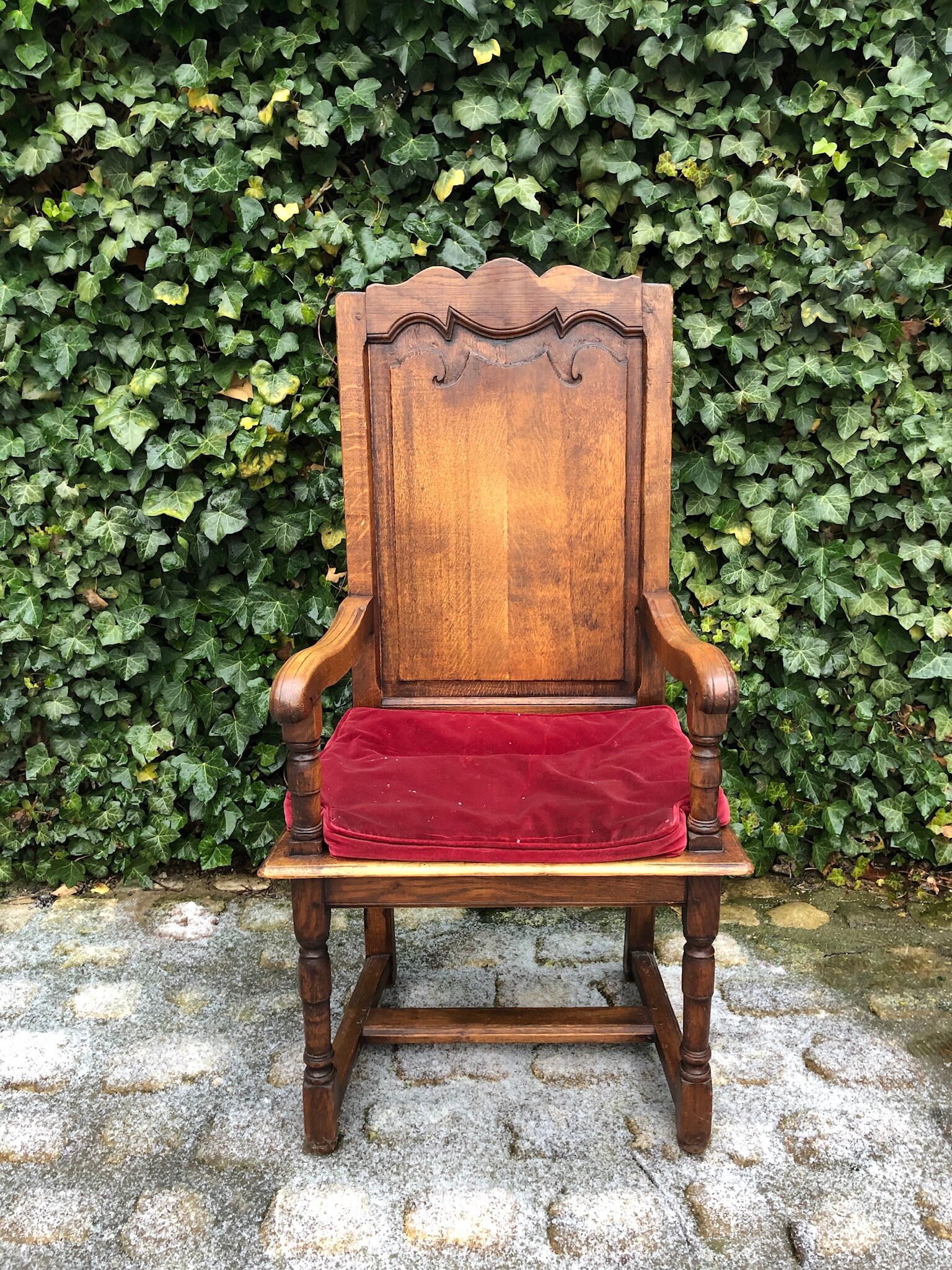 Wooden armchair with velvety red cushion