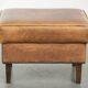 Cowhide ottoman with a beautiful patina finished with decorative nails