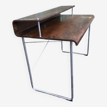 Design desk in formed glued laminated wood with chrome tubular base.