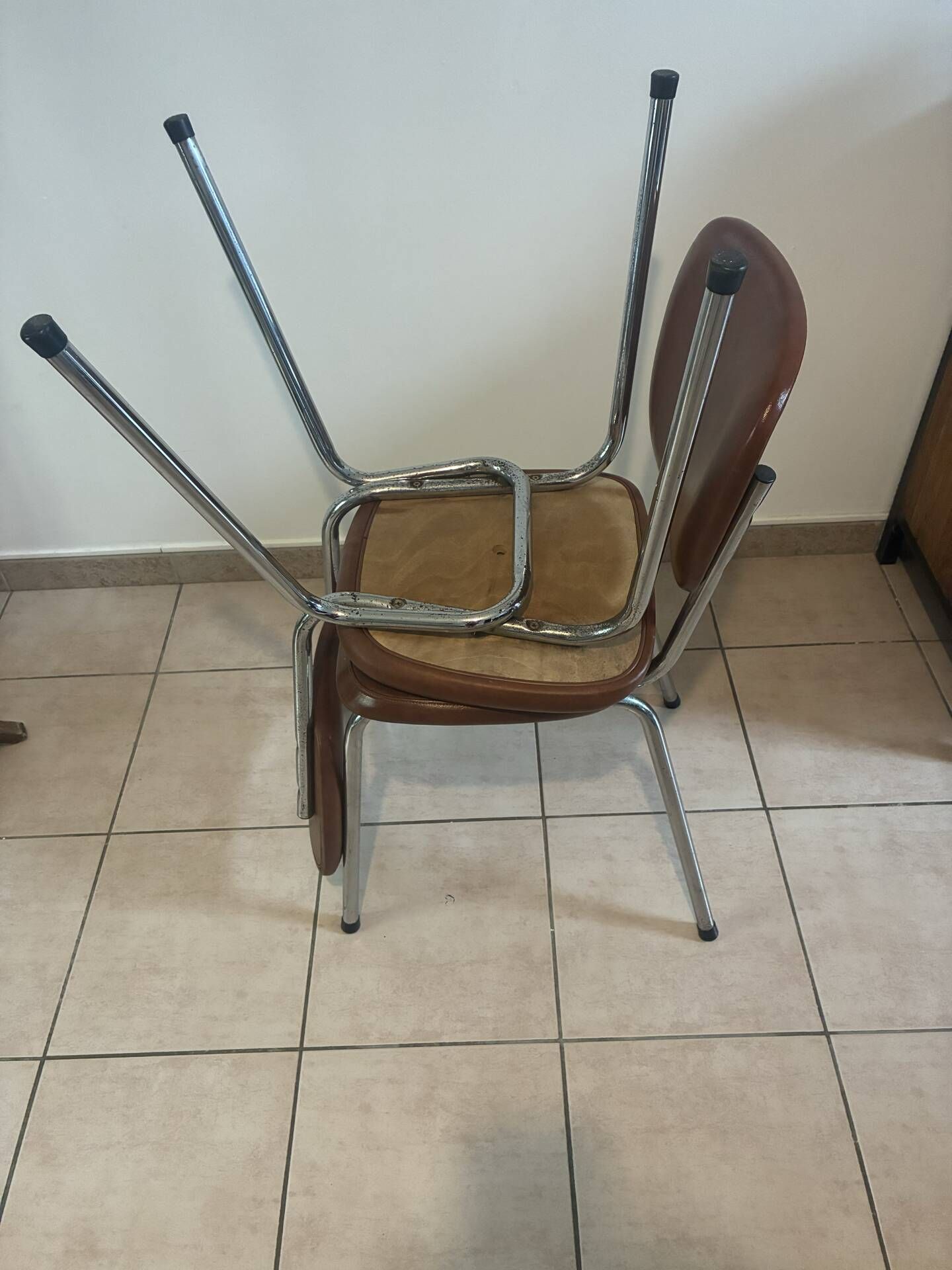 Two brown faux leather chairs.