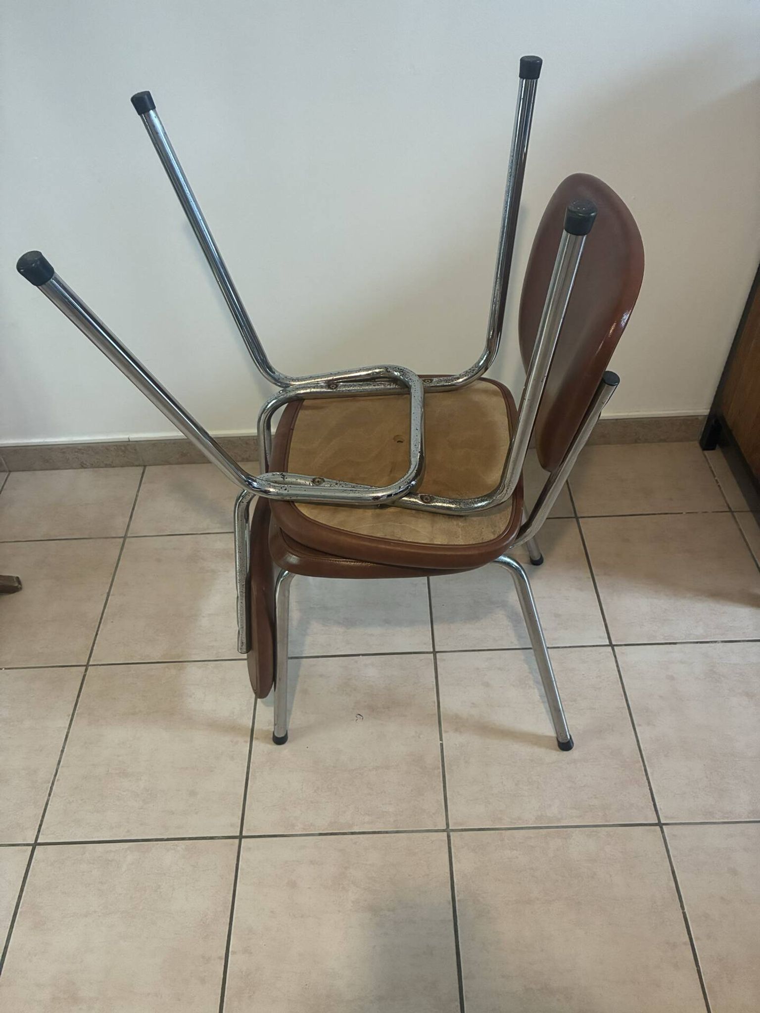 Two brown faux leather chairs.