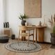 Round jute rug with white relief patterns.