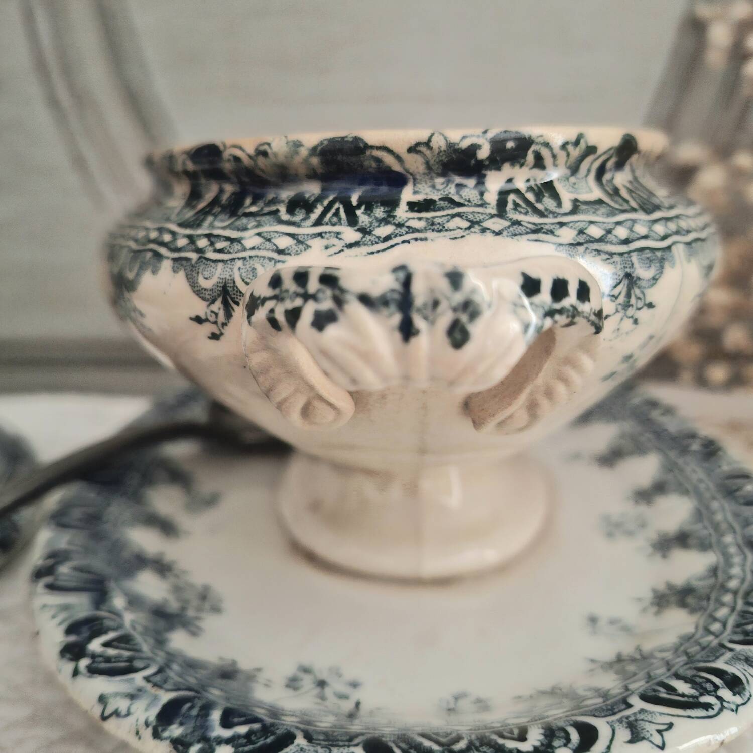 Antique iron earthenware sauceboat on a frame