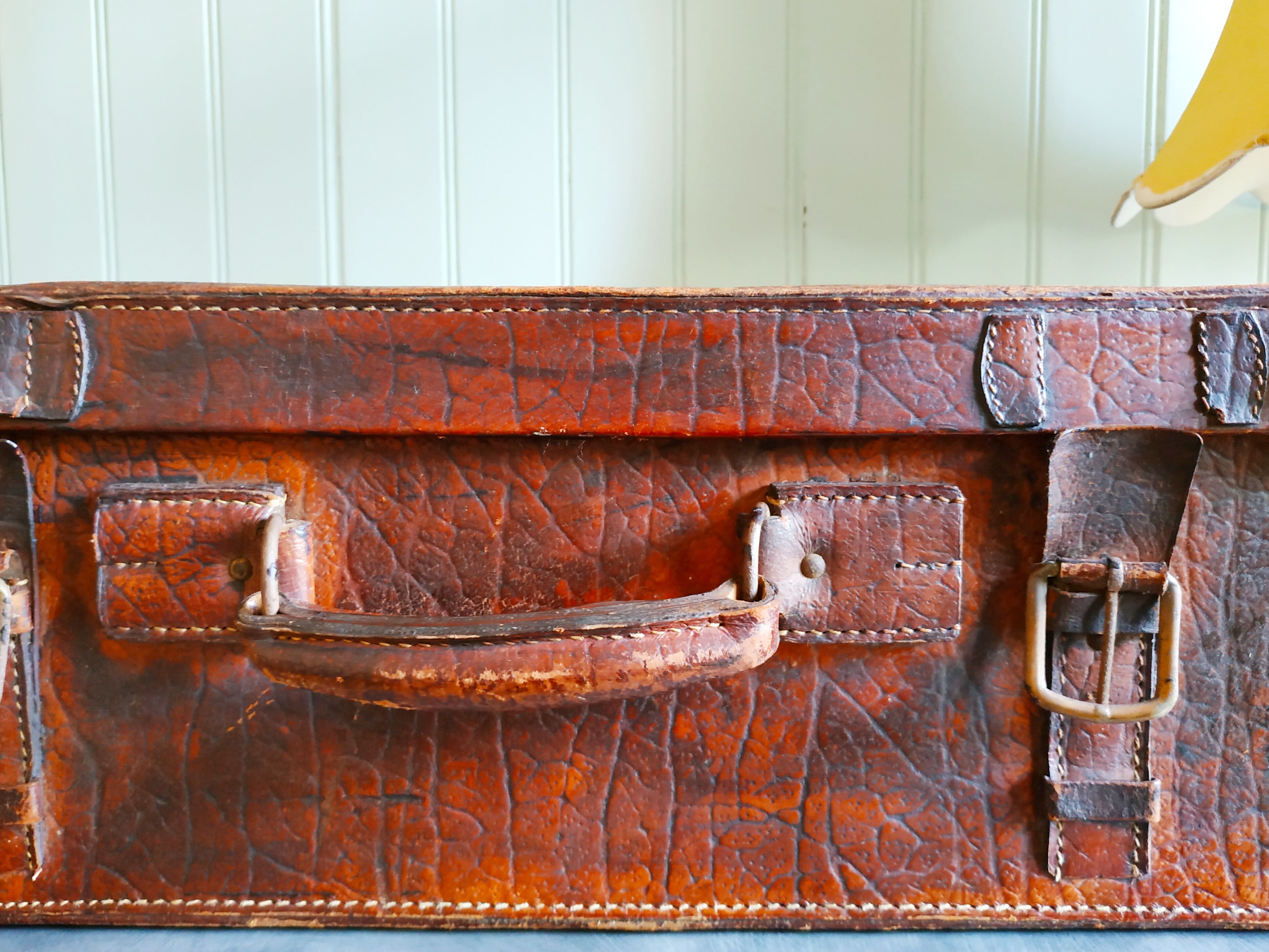Old cardboard suitcase covered with patinated leather