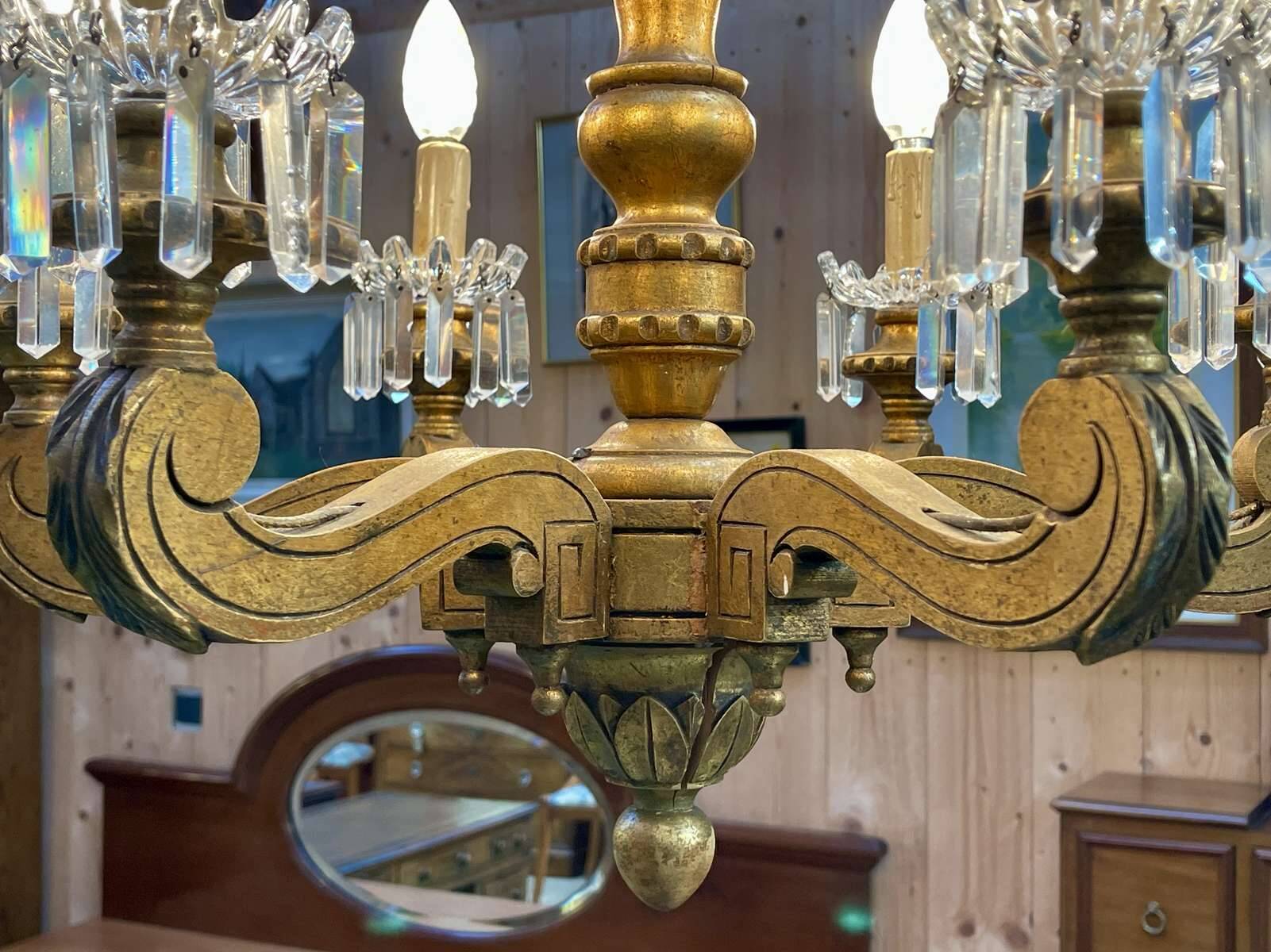 Golden wooden chandelier with crystal pendants from the 19th century.