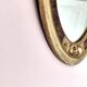 Antique medallion mirror with a gilded and relief-carved frame.